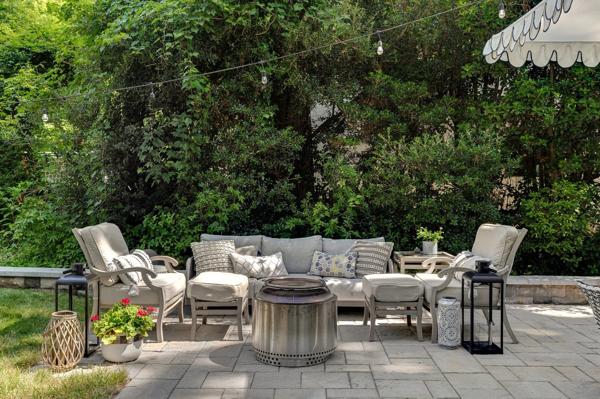 A cozy outdoor seating arrangement featuring cushioned chairs, a fire pit