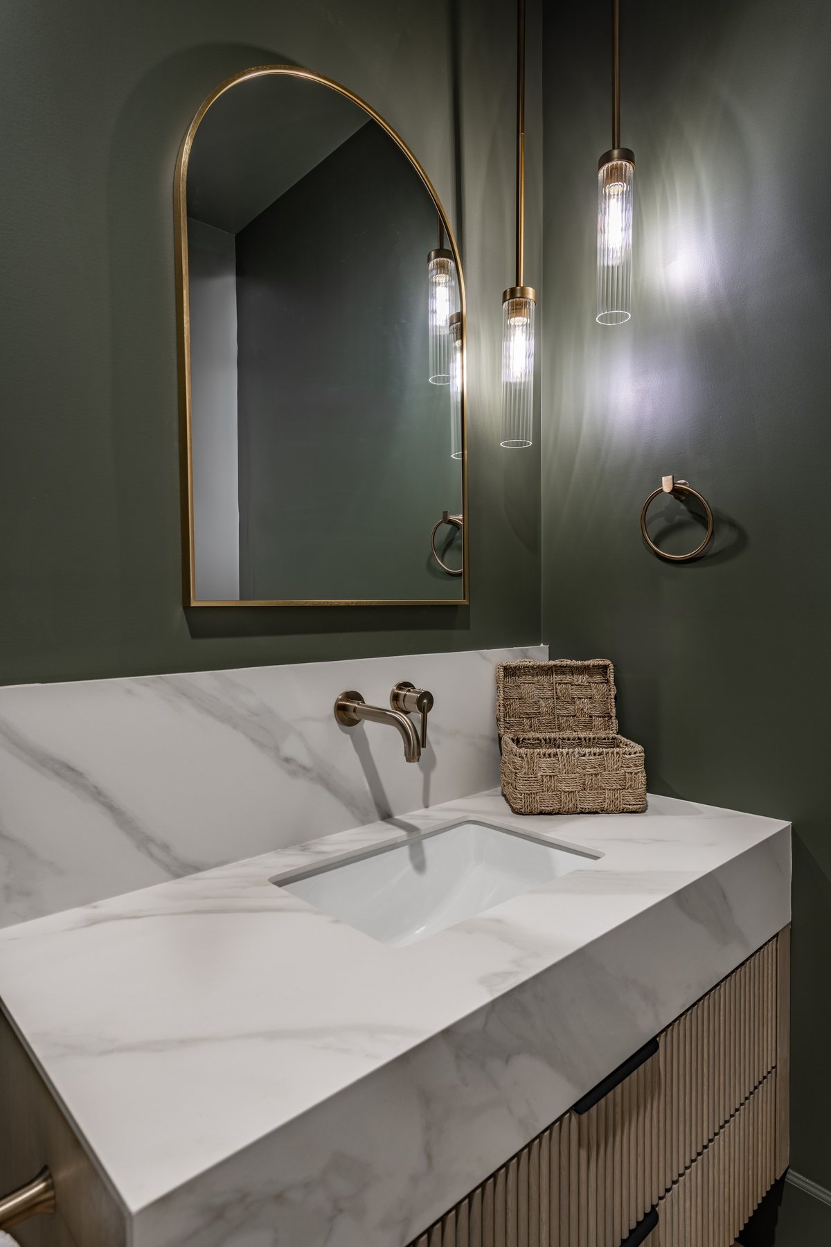powder room interior with dark green painted walls pendant lighting large mirror marble countertop