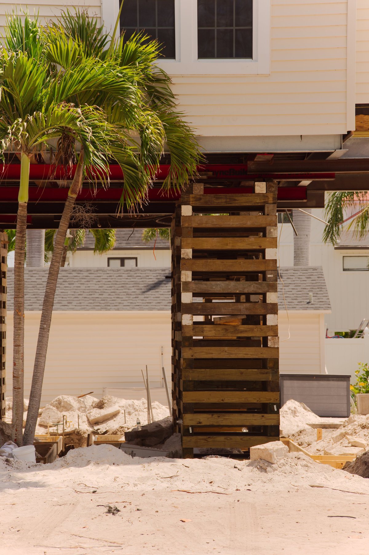 Raised coastal house supported on stacked wooden cribbing for foundation repair and elevation work