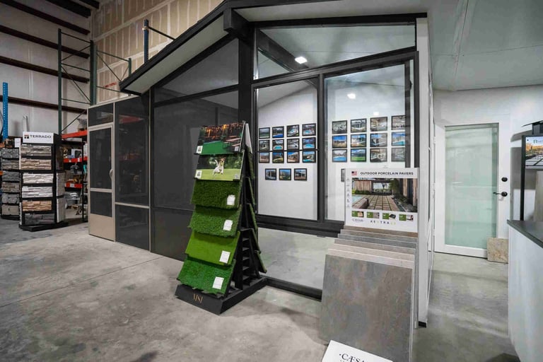 Interior view of a modern office or retail space with glass-walled conference rooms, green storage shelving, and product displays on walls