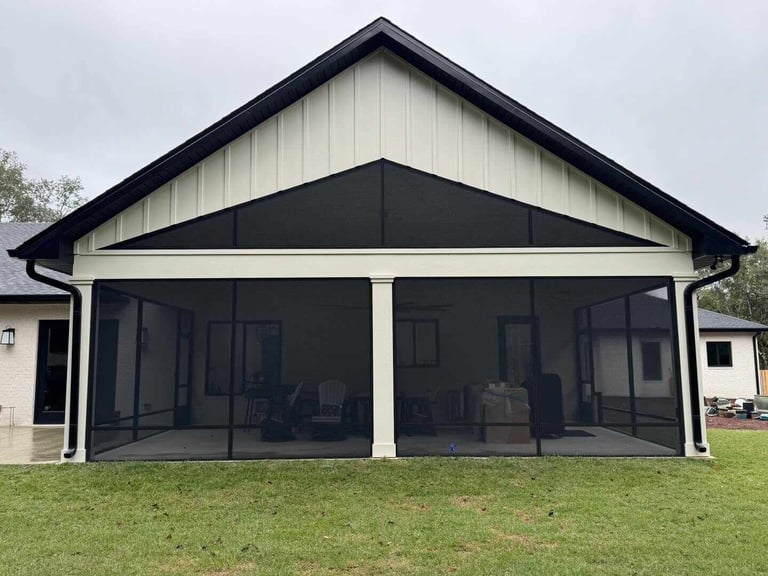Modern gable roof carport with black and white trim, screened panels, and white columns on a grassy lawn