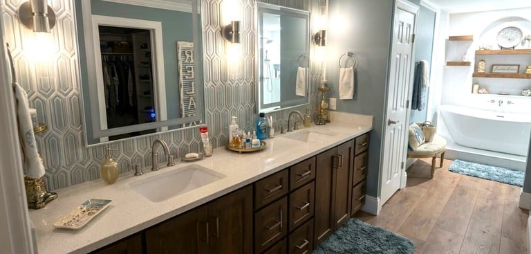 Modern bathroom with dual vanity, white countertop, dark wood cabinets, geometric wallpaper, and spa-like fixtures.